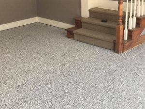 A basement with an epoxy floor coating that has a stone pattern.