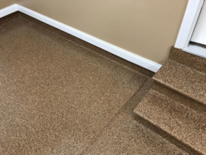 A basement with concrete steps and flooring coated with epoxy.