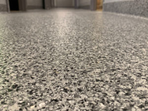 A close-up image of a coated concrete floor with natural stone effects on the inside of a home.