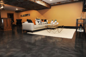 Entertainment space with grey Liquid Art metallic epoxy floor coating on the floor.