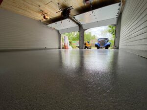 An empty garage has a newly coating PVA full broadcast floor coating.