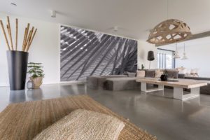 Modern living room features gray coated concrete floors and gray and tan furnishings