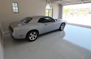 Garage with shiny gray floor coating and a silver car