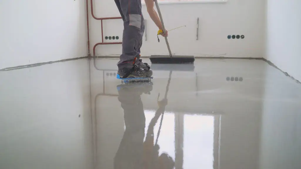 Using a spiked roller to backroll the epoxy floor installation